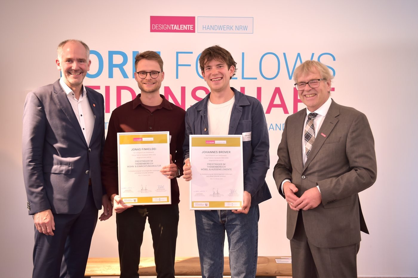 Vier Männer bei der Preisverleihung von DesignTalente Handwerk NRW; zwei halten ihre Urkunden.
