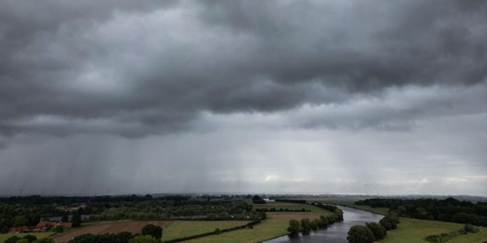 Dunkle Regenwolken ziehen über den Ort an der Weser (Luftaufnahme mit einer Drohne).