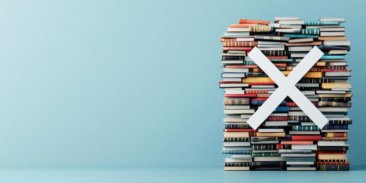 Auf dem Bild sieht man einen Stapel Bücher, davor ein großes weißes X. Diese Komposition soll Bücherverbote symbolisieren.© stock.adobe.com - Weerapat (Generiert mit KI)