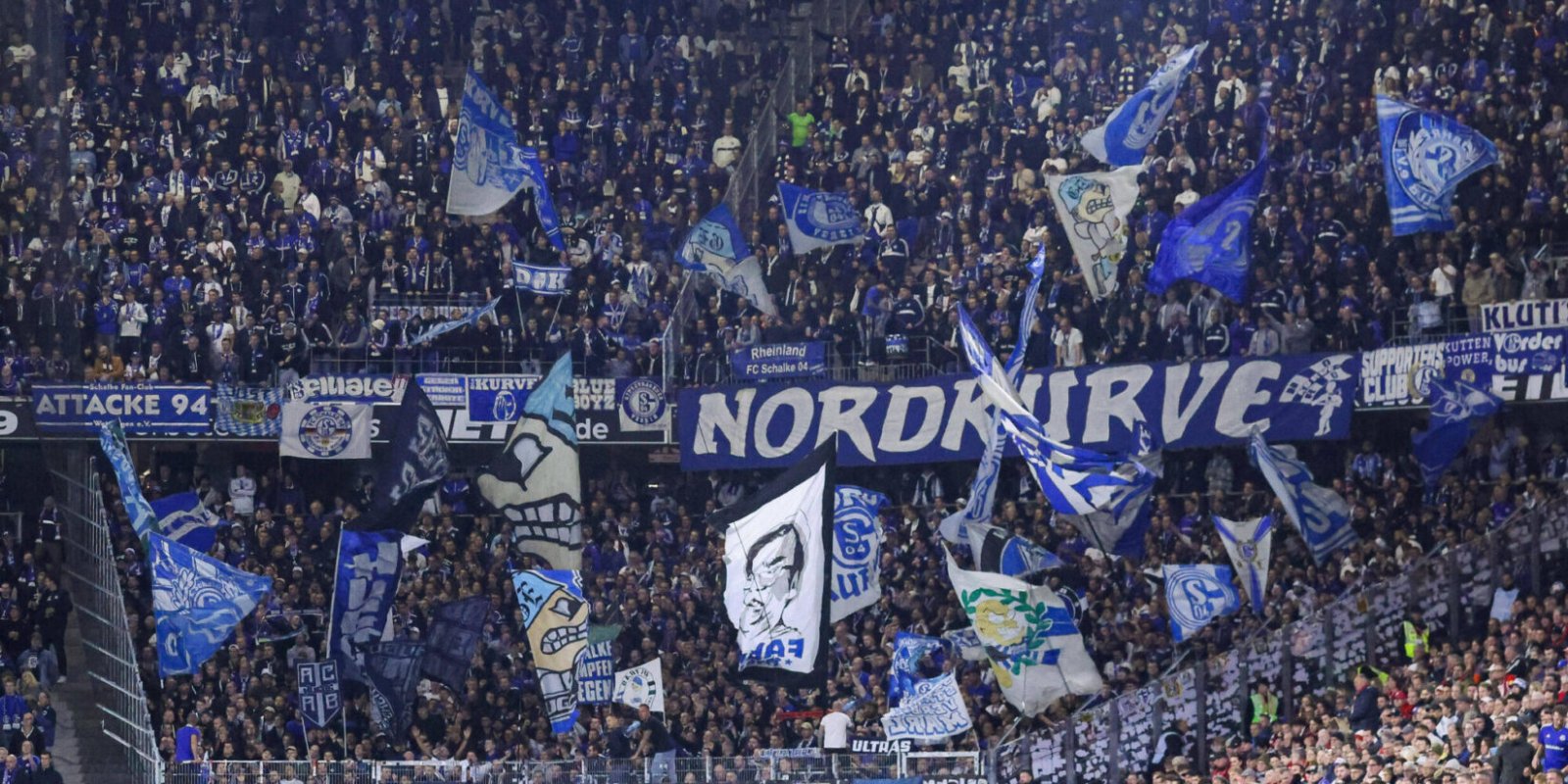 Die mitgereisten Fans vom S04 mit Fahnen und Bannern in der Fankurve in Freiburg am 4. Spieltag.